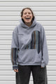 person wearing a grey hoodie with plaid inserts, upcycled in canada