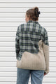 person wearing an upcycled shirt, green plaid and cream knit sewn together, repurposed in canada