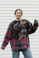 person wearing bleached sweater that is sewn together with red plaid shirt, upcycled in canada