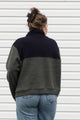 person wearing a fleecy half zip pull over, green and black, upcycled in canada
