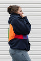 Person wearing a navy hoodie with a colourful rainbow design upcycled in canada