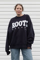 Person wearing a black 'ROOTS Canada' sweatshirt, upcycled in canada