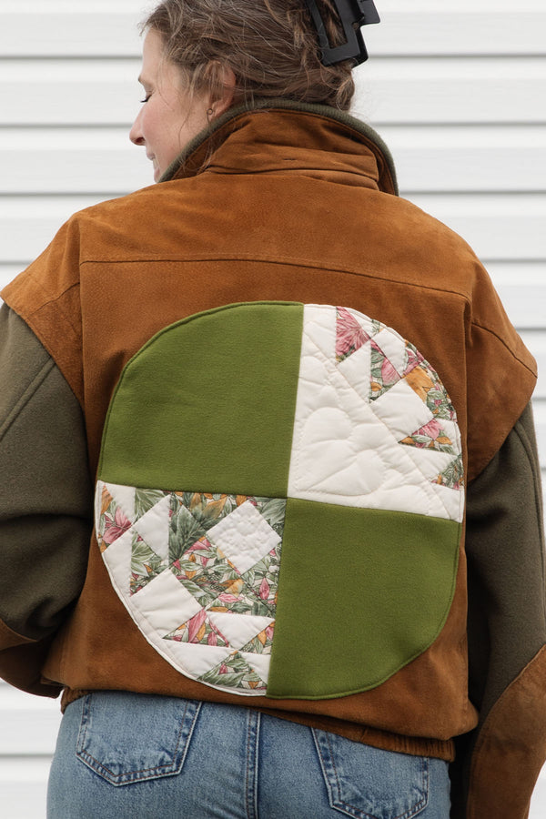 person wearing a wool & suede vintage jacket, upcycled in canada. featuring green, white and pink quilted circle back detail