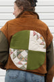 person wearing a wool & suede vintage jacket, upcycled in canada. featuring green, white and pink quilted circle back detail