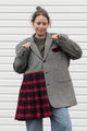 Person wearing a gray blazer sewn together with a red plaid skirt, upcycled in canada