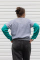 Person wearing a teal, blue and grey vintage sweater, upcycled in canada