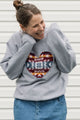 Woman wearing a gray sweatshirt with a colorful heart design against a white background