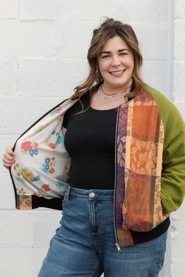 leafy table cloth upcycled into bomber jacket, orange, purrple and gold jacket with green sleeves, handmade in canada