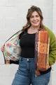 leafy table cloth upcycled into bomber jacket, orange, purrple and gold jacket with green sleeves, handmade in canada