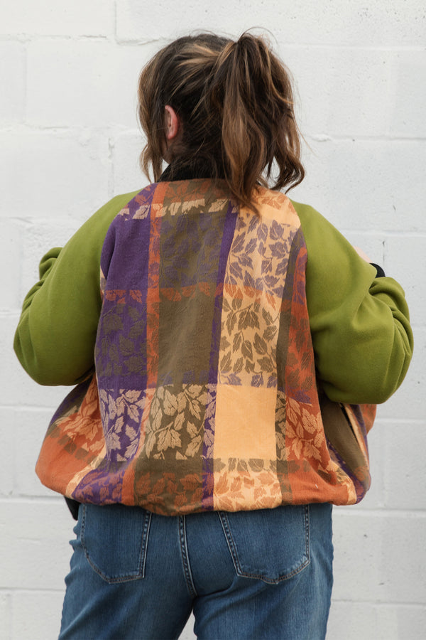 leafy table cloth upcycled into bomber jacket, orange, purrple and gold jacket with green sleeves, handmade in canada