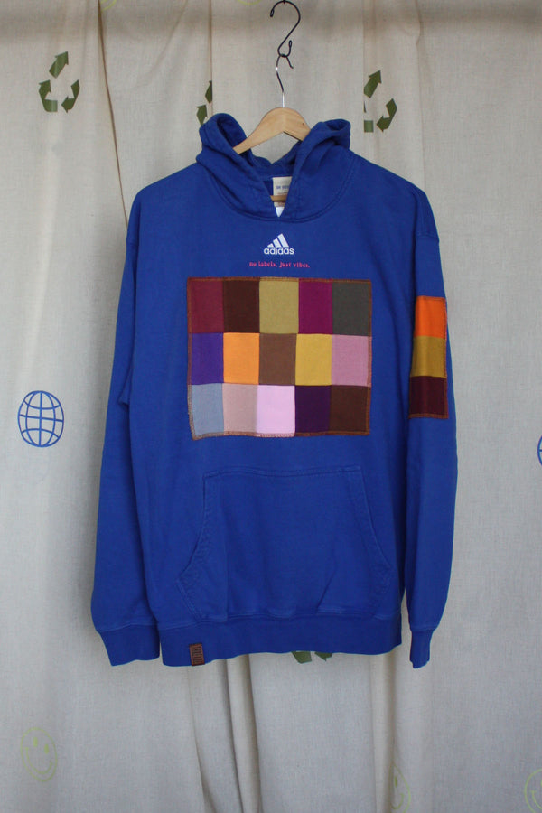 blue hoodie with colour patches on the front, sleeve and hood. upcycled in canada