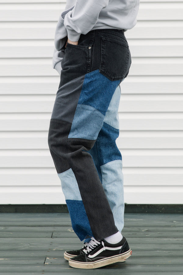 Person wearing patchwork jeans with a white background