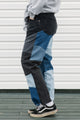 Person wearing patchwork jeans with a white background
