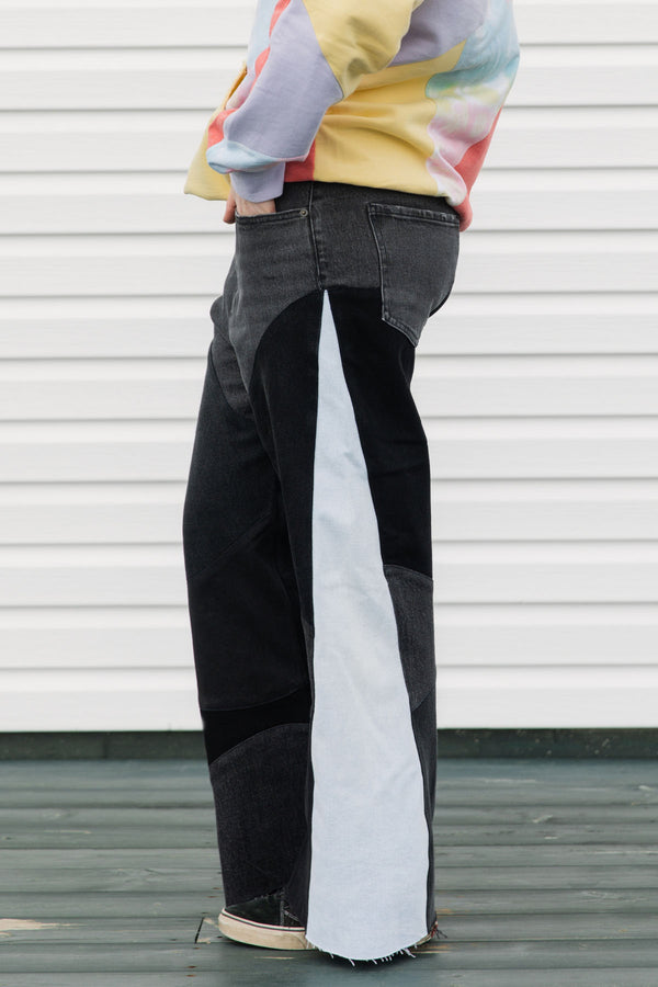 Person wearing a colorful sweater and black pants standing against a white background, upcycled in canada