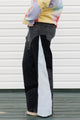 Person wearing a colorful sweater and black pants standing against a white background, upcycled in canada
