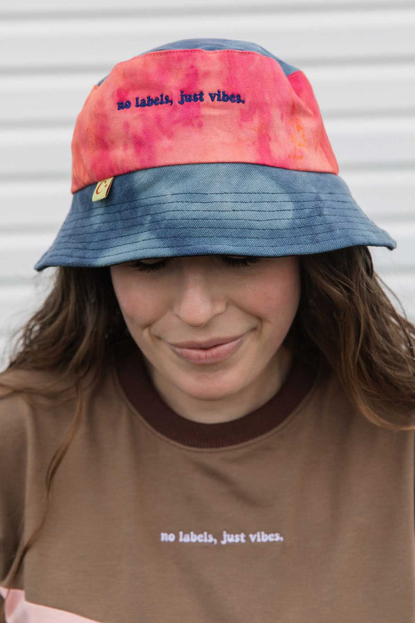 colourful upcycled bucket hat, each embroidered with 'no labels, just vibes.' and are reversible with solid colours, made in canada