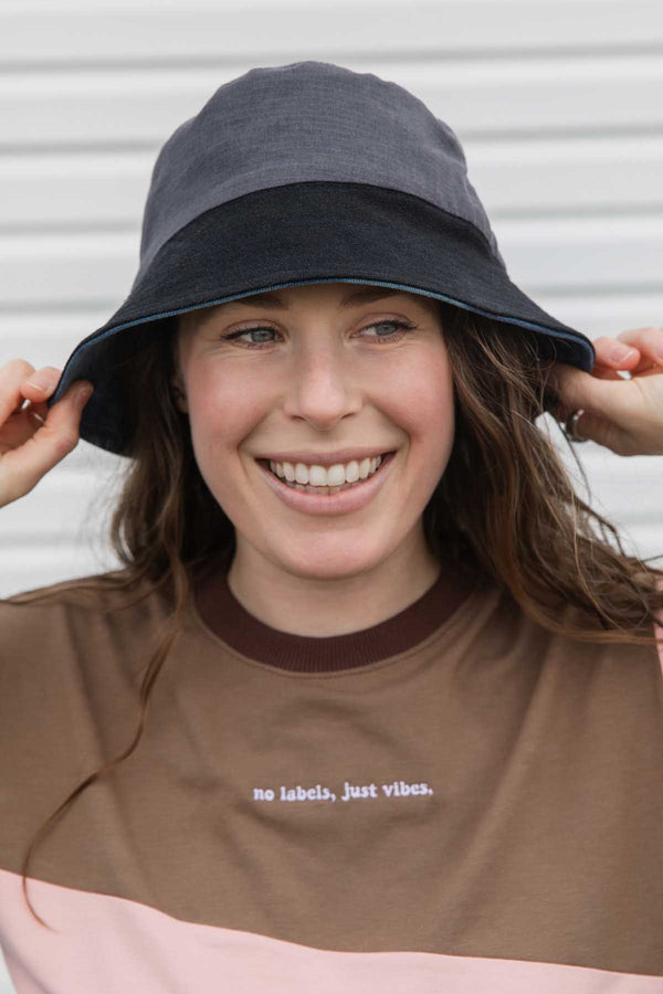 colourful upcycled bucket hat, each embroidered with 'no labels, just vibes.' and are reversible with solid colours, made in canada