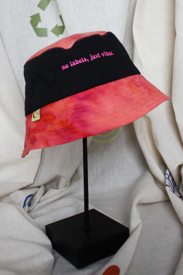 colourful upcycled bucket hat, each embroidered with 'no labels, just vibes.' and are reversible with solid colours, made in canada