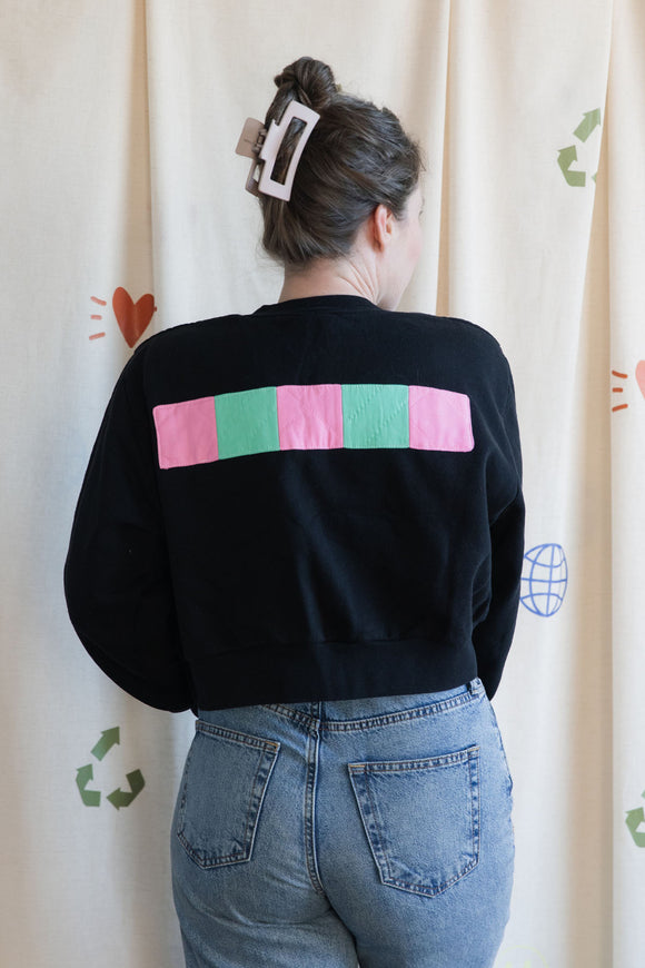 Person wearing a black sweatshirt with a colorful butterfly design, upcycled in canada