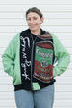 Person wearing a jacket with Campbell's Tomato Soup design against a white wall