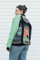 Person wearing a colorful vintage-style jacket with soup can designs against a white background