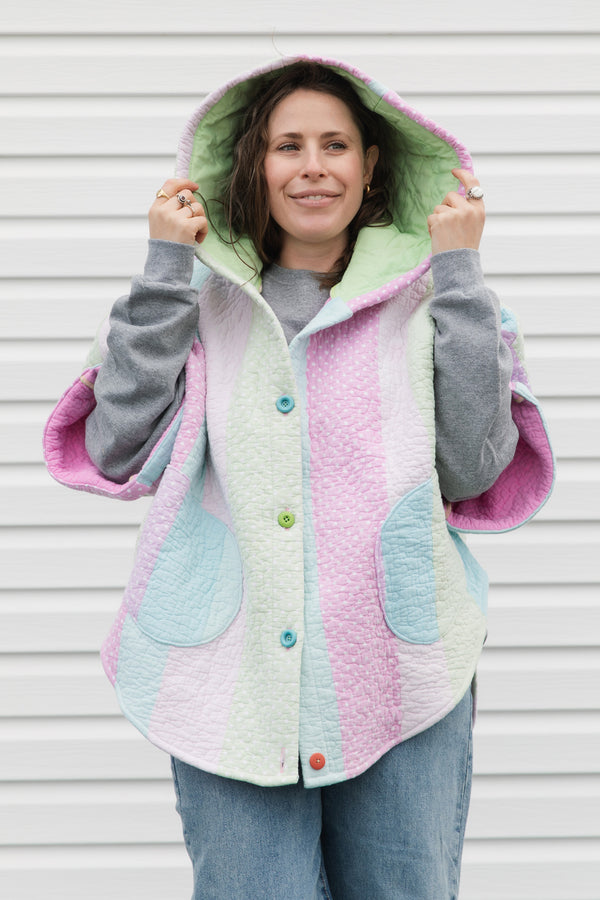 pink, green and blue pastel quilt turned poncho, with oversized hood, pockets and button up front, repurposed in canada