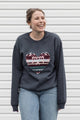 Woman wearing a dark gray sweatshirt with a colorful heart design sewn in canada
