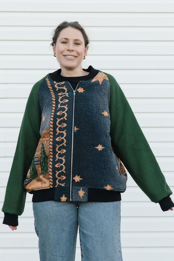 Person wearing a green and patterned jacket, featuring a starry night in the desert against a white background