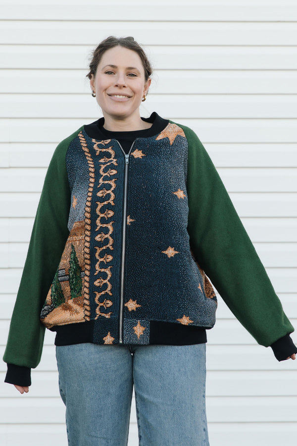 Person wearing a green and patterned jacket, featuring a starry night in the desert against a white background