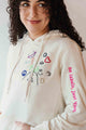 unisex cream hoodie with hand embroidered doodles, upcycled clothing, embroidered with no labels, just vibes on sleeve