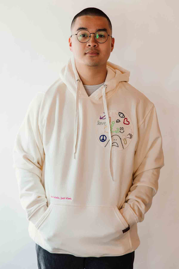 unisex cream hoodie with hand embroidered doodles, upcycled clothing, embroidered with no labels, just vibes on sleeve