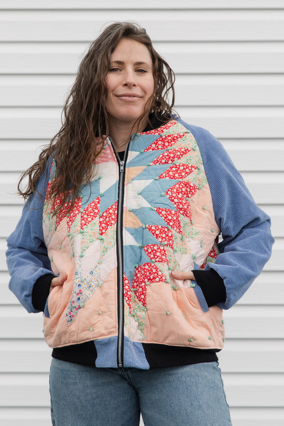 quilt turned bomber jacket, upcycled and repurposed. featuring red, peach, blues and greens with periwinkle sleeves. made in canada