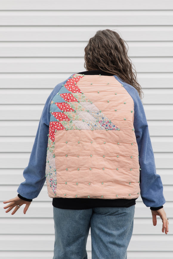 quilt turned bomber jacket, upcycled and repurposed. featuring red, peach, blues and greens with periwinkle sleeves. made in canada