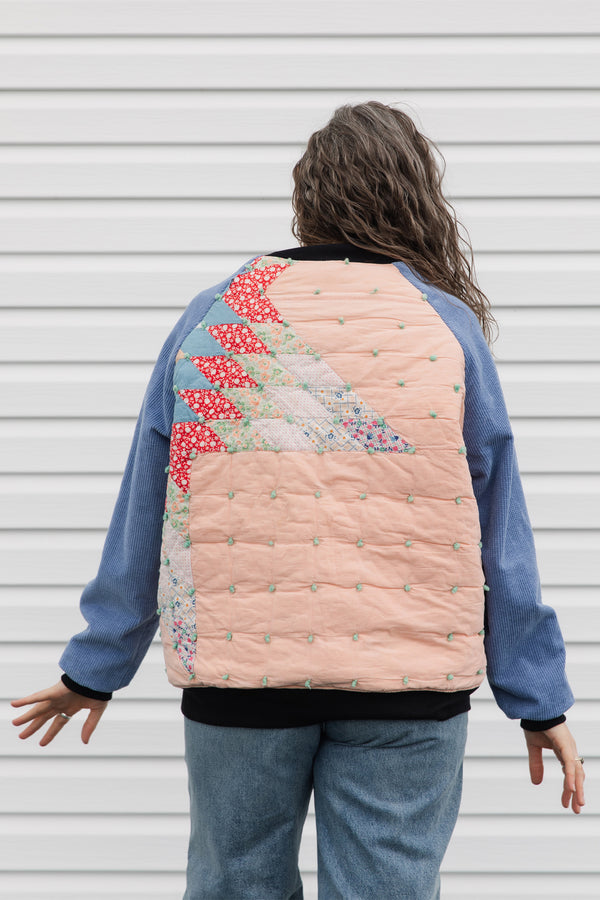 quilt turned bomber jacket, upcycled and repurposed. featuring red, peach, blues and greens with periwinkle sleeves. made in canada