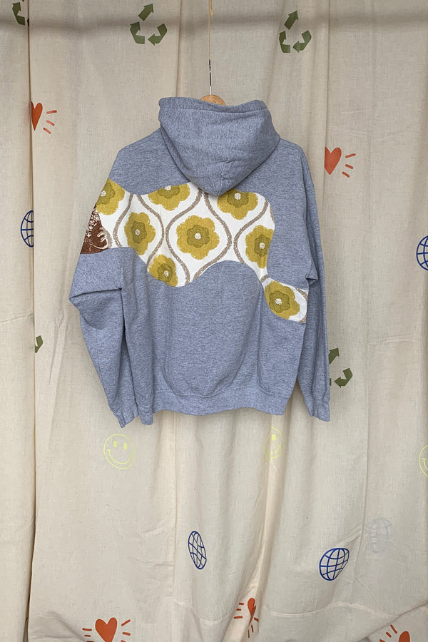 grey hoodie with colourful motif on front, sleeve and back. this upcycled gem is one of a kind and uses drapery samples to elevate this hoodie, repurposed in caanda