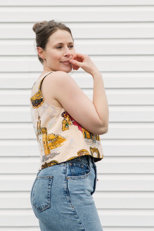 Woman wearing a colorful sleeveless top with graphic designs against a white background, matador and spanish print, upcycled in canada