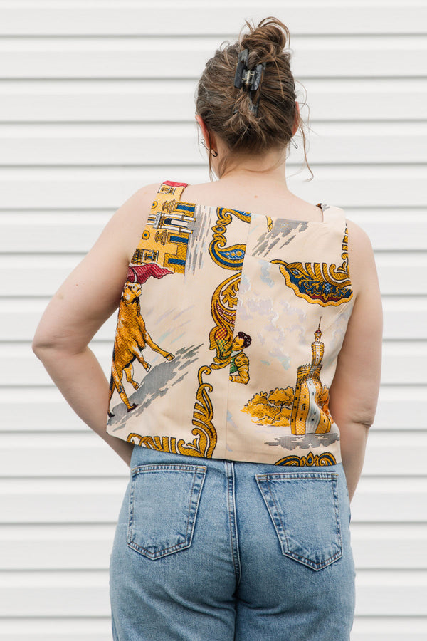 Woman wearing a colorful sleeveless top with graphic designs against a white background, matador and spanish print, upcycled in canada