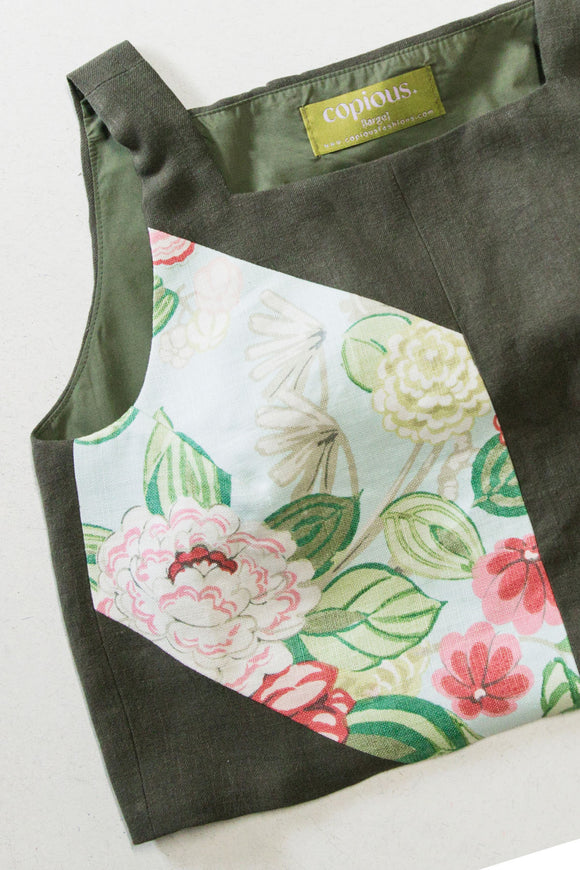 Green tank top with floral fabric on the front on a white background, upcycled in canada