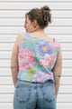 Person wearing a colorful floral sleeveless top against a white background