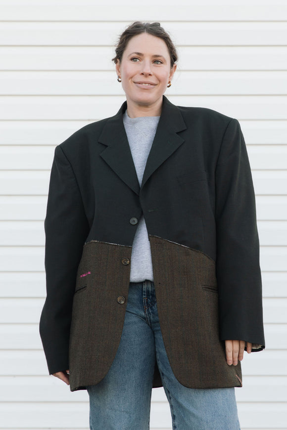 Person wearing a black and brown coat against a white background