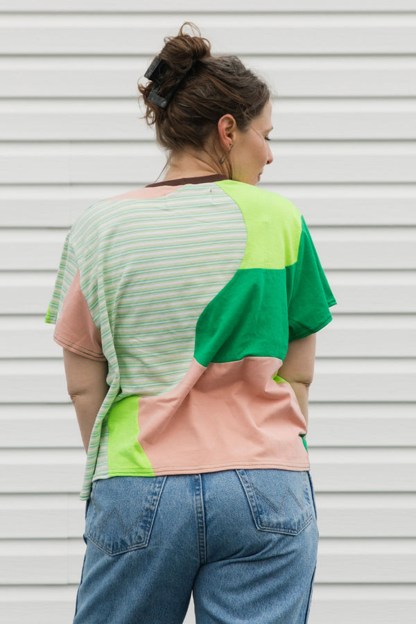 Person wearing a colorful shirt with a neutral background