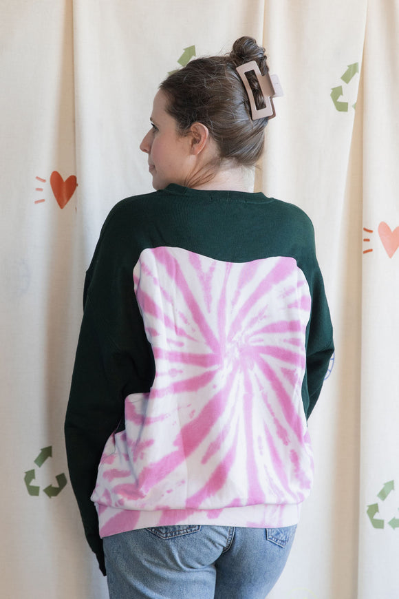 Person wearing a green and pink tie-dye sweatshirt, upcycled in canada