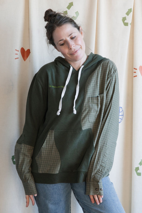 Person wearing a green hoodie with green plaid sleeves upcycled in canada
