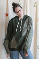 Person wearing a green hoodie with green plaid sleeves upcycled in canada