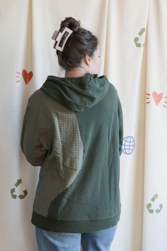 Person wearing a green hoodie with green plaid sleeves upcycled in canada