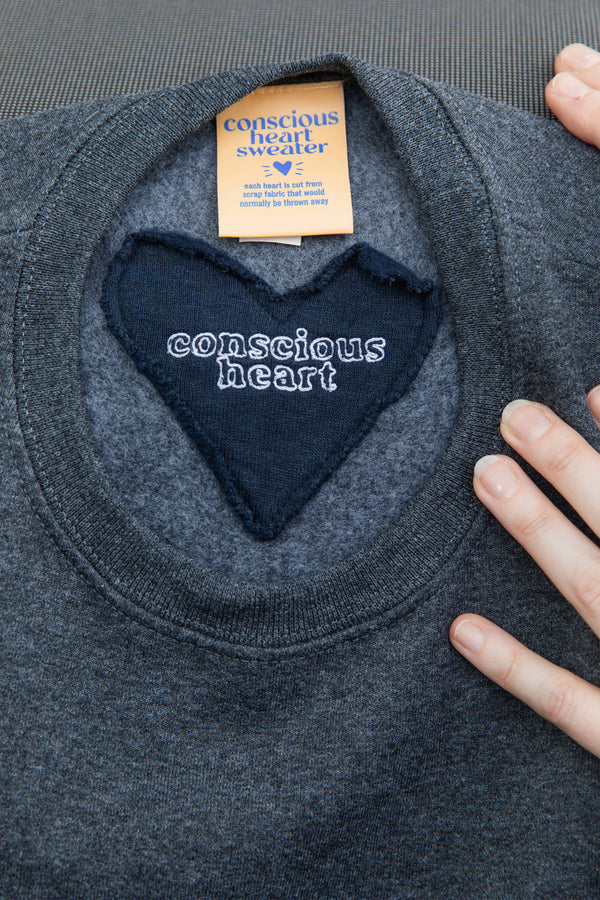 conscious heart sweater tag on back neck, featured on unisex grey sweater, made in canada