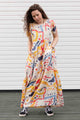 maxi dress with sleeve, pockets and a slight empire waist. dress has abstract colourful print. made in canada