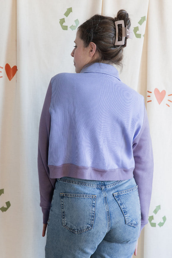 Woman wearing a purple button up sweater with collar, upcycled in canada