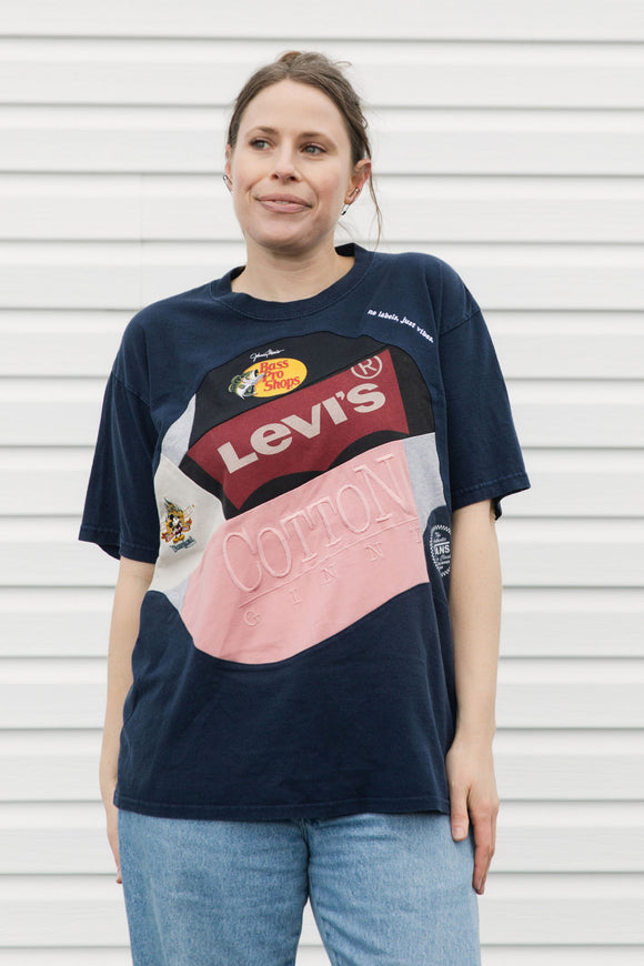 Person wearing an upcycled t-shirt featuring lots of different logos, made in canada