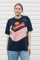 Person wearing an upcycled t-shirt featuring lots of different logos, made in canada